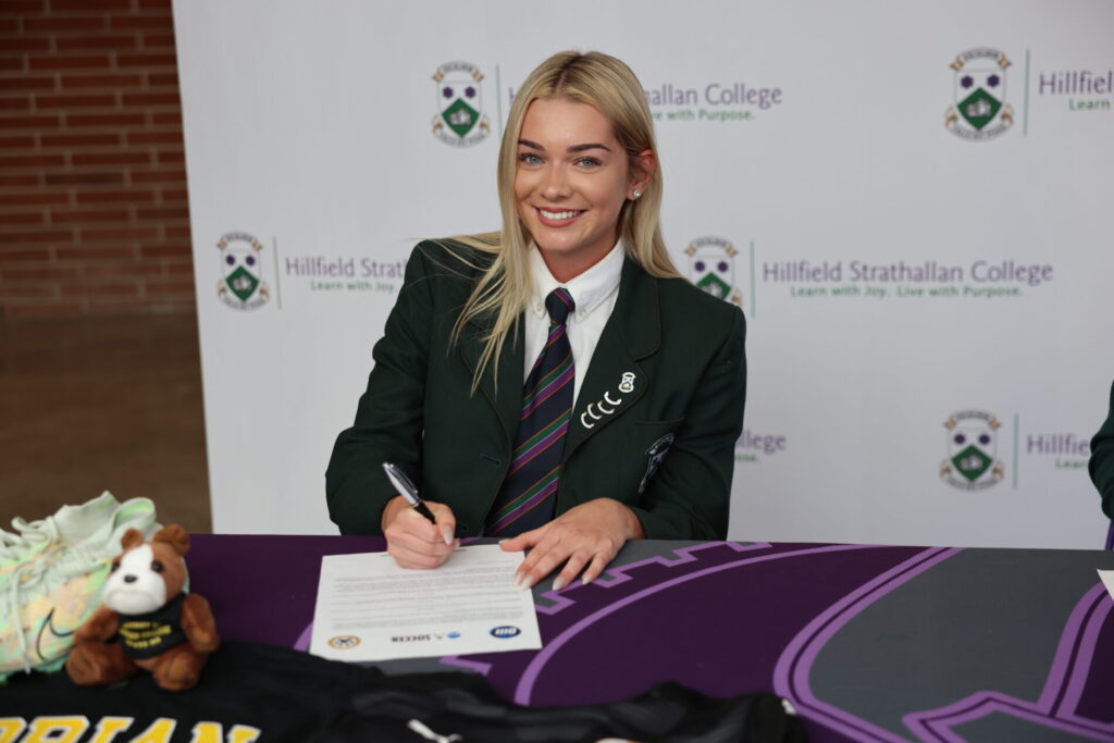 hsc student signing paper at table