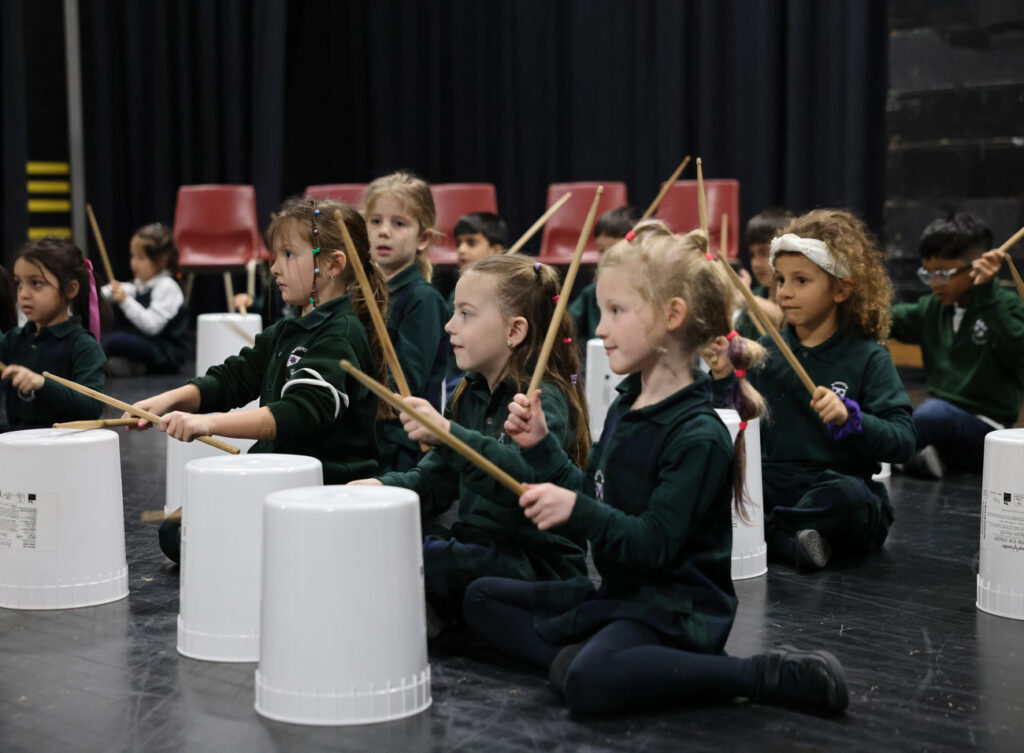 youth playing buckets as drums